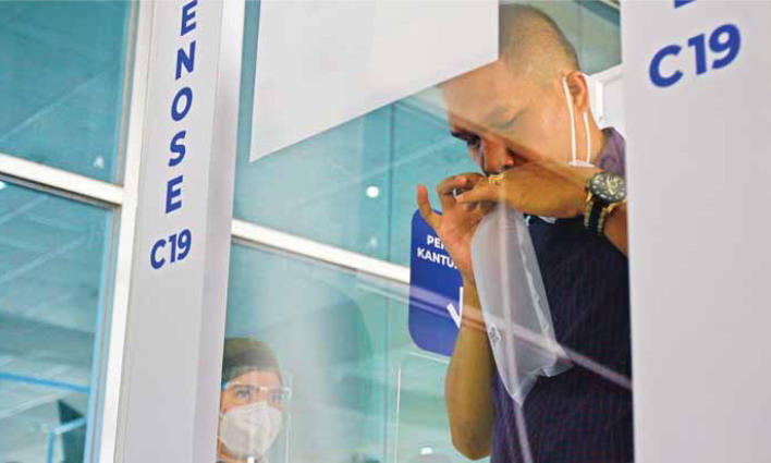 DETEKSI DINI: Seorang penumpang pesawat menjalani pemeriksaan Covid-19 menggunakan alat GeNose di Bandara Tjilik Riwut, Senin (26/4/2021). FOTO:DENAR