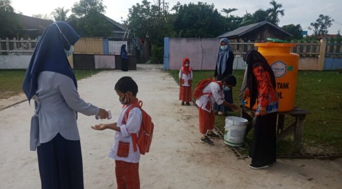 PROTOKOL KESEHATAN: Peserta didik dari Raudhatul Adfhal (RA) saat menjankan protokol kesehatan dengan mencuci tangan dan periksa suhu badan sebelum masuk keruang kelas ini telihat, Selasa (25/5/2021).FOTO:BAHRI/KALTENGPOS
