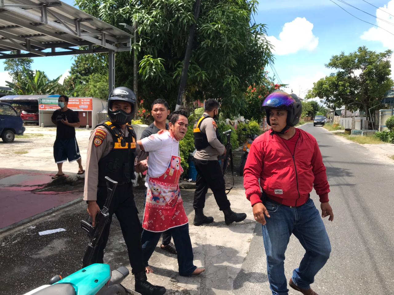 Menggunakan celemek dan membawa sebilah pisau