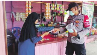 MASKER GRATIS: Anggota Polsek Laung Tuhup, Polres Murung Raya rutin membagikan masker kepada warga secara gratis.