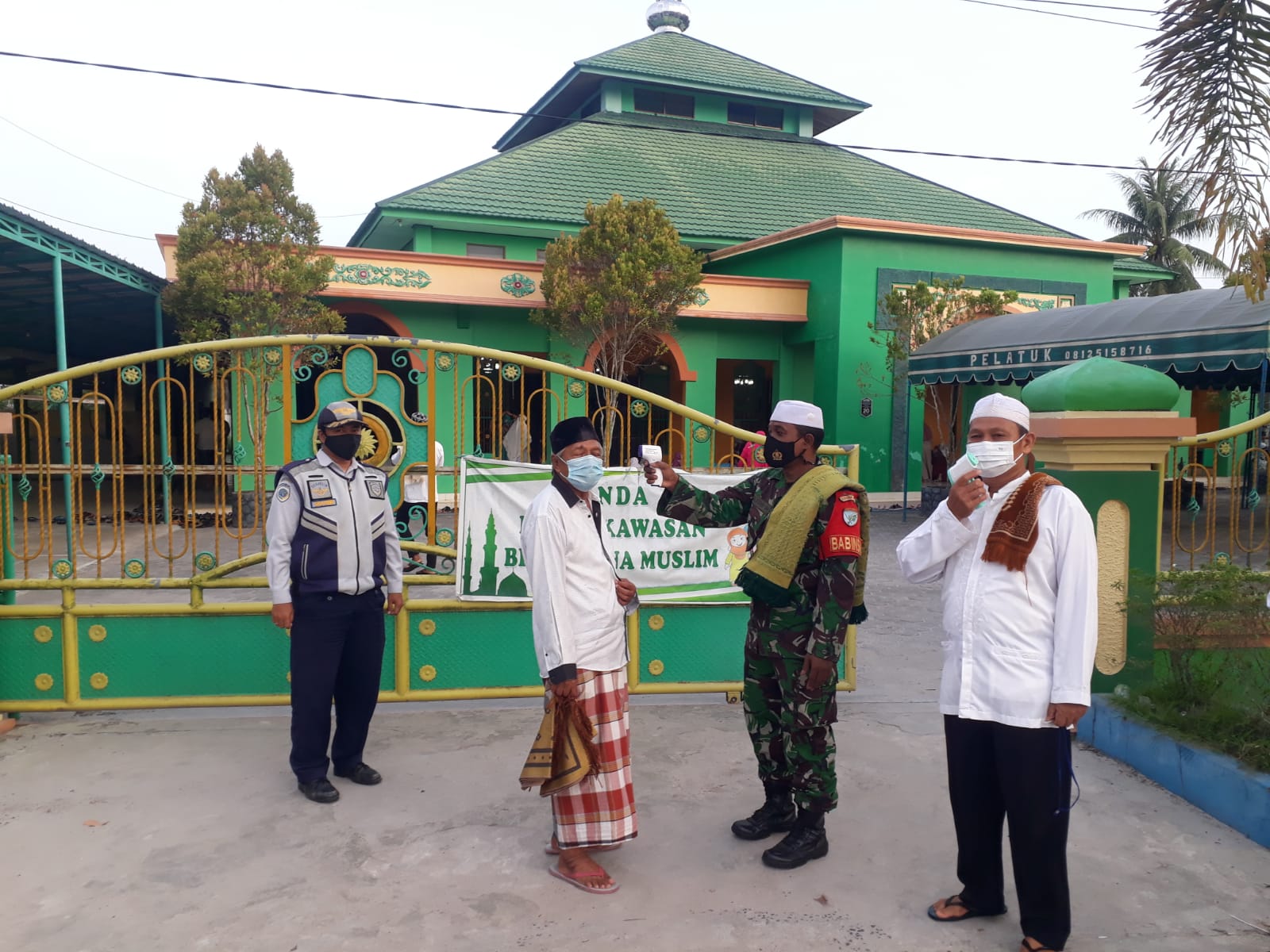 CEK SUHU TUBUH : Babinsa Koramil 1016-01/Pahandut Serka M. Arifin bersama petugas lainnya melakukan pengecekan suhu tubuh kepada para jemaah yang akan mengikuti Shalat Idul Adha di Masjid Darul Muttaqin, Selasa (20/7/2021) KODIM 1016/PLK UNTUK KALTENG.CO