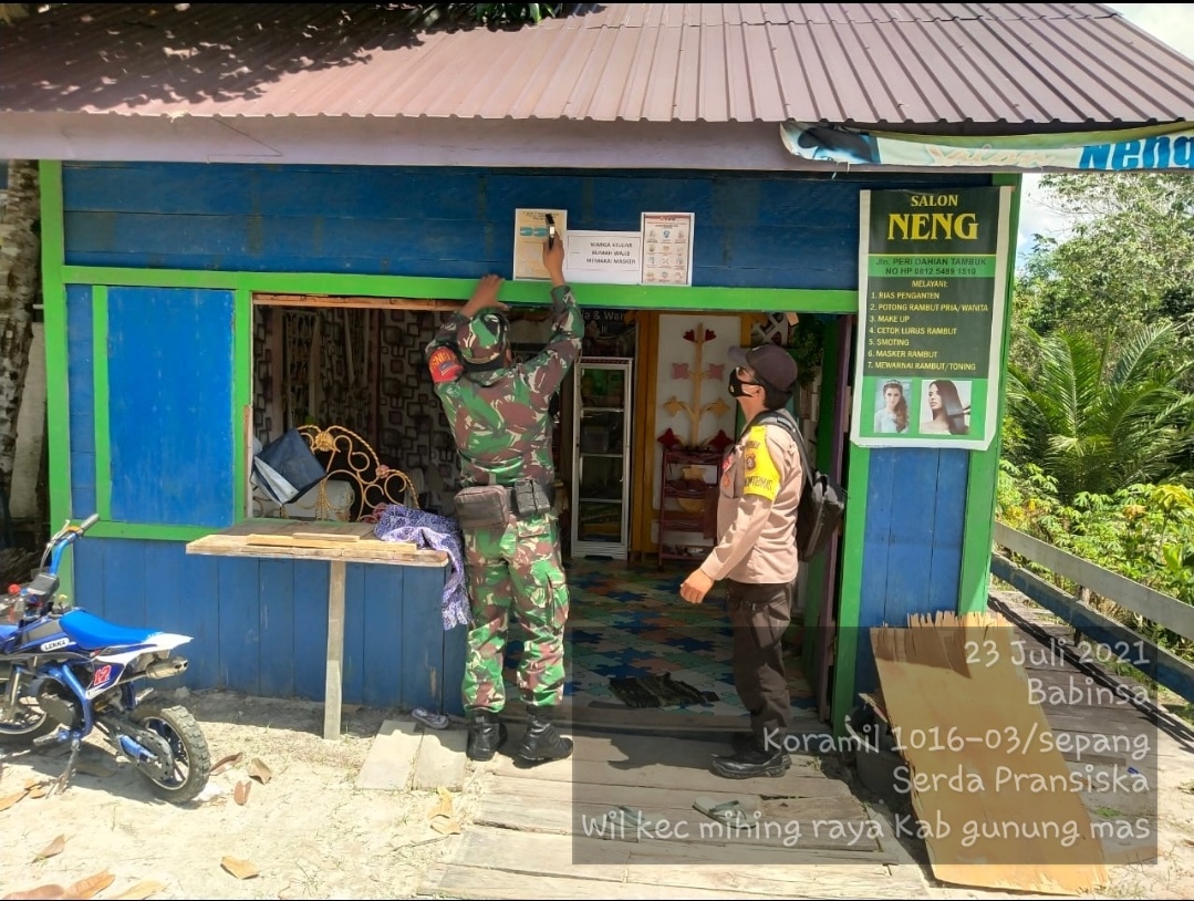 KONTROL WARGA : Petugas PPKM Kecamatan Mihing Raya, Kabupaten Gunung Mas memasang imbauan Protokol Kesehatan (Prokes) di rumah warga Jumat (23/7/2021). KODIM 1016/PLK UNTUK KALTENG.CO