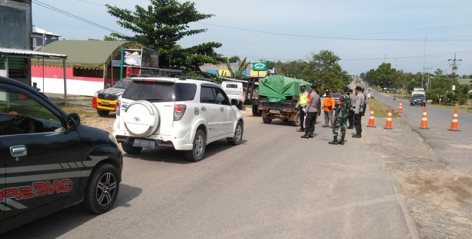 POS PENYEKATAN: Tim gabungan mengecek pengendara yang lewat di Desa Karang Mulya./PENREM 102/Pjg