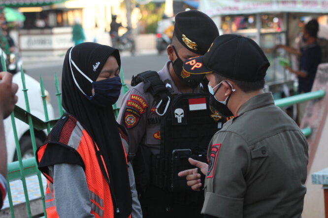 DISANKSI: Salah seorang warga yang melanggar prokes diberikan sanksi membacakan Pancasila di Jalan Sethadji, Senin (9/8/2021)./DENAR/KALTENG POS