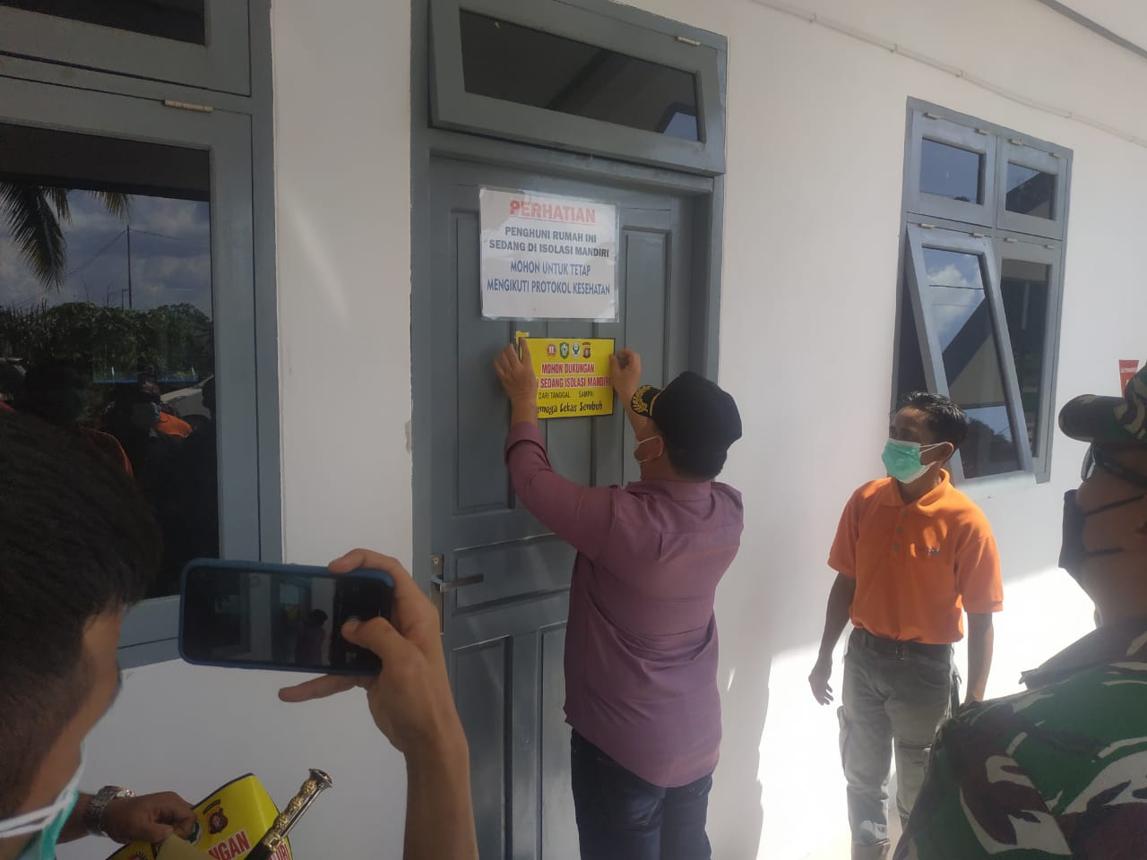 STIKER ISOMAN: Bupati Kotim, H Halikinnor memasang stiker mohon dukungan, sedang isolasi mandiri di salah satu ruang isolasi mandiri PBS, Sabtu (31/7/2021)./humas