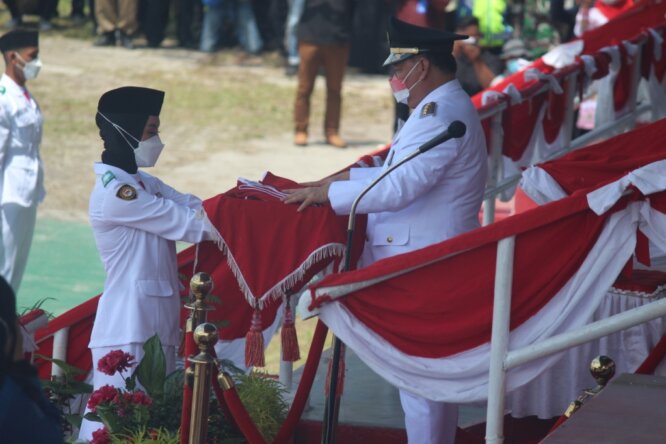 BENDERA PUSAKA: Bupati Kabupaten Kotim H Halikinnor menyerahkan Bendera Pusaka saat peringatan HUT ke-76 RI di Stadion 29 November Sampit, Selasa (17/8/2021)./BAHRI