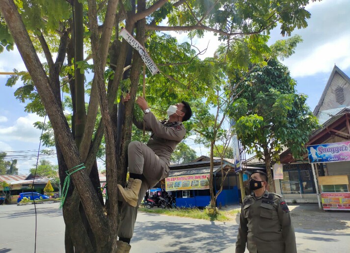 PENERTIBAN: Petugas SatpolPP dan Damkar Kapuas melakukan penertiban iklan usaha di Kota Kuala Kapuas./HUMAS