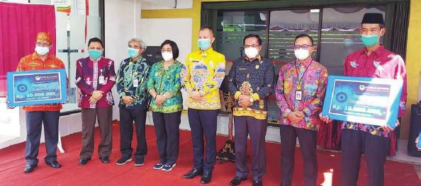 MENGHADIRI : Ketua DPRD Gunung Mas Akerman Sahidar (kanan batik hitam corak emas) saat menghadiri peresmian Kantor Cabang Bank Kalteng di Kecamatan Sepang, beberapa waktu lalu.