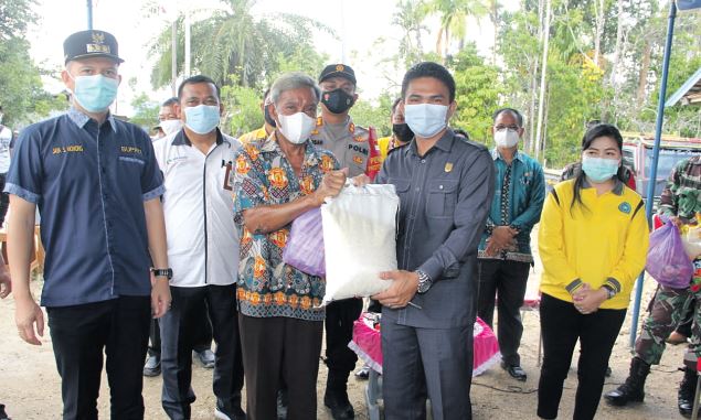 MENYERAHKAN : Wakil Ketua I Dewan Perwakilan Rakyat Daerah Gunung Mas Binartha menyerahkan bantuan kepada warga terdampak banjir, Kamis (9/9).