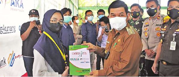 SEMANGAT: Bupati Barito Timur Ampera AY Mebas mengalungkan tanda peserta dan buku Program Cemara ketika membuka pelatihan di Tenis Indoor Komplek Nansarunai Tamiang Layang, Senin (27/9).