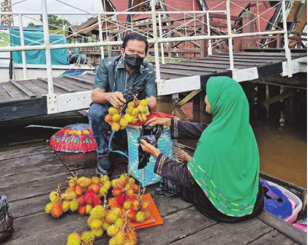 TERJUN KE MASYARAKAT: Algrin Gasan berbincang dengan warga yang menjajakan buah di Pelabuhan Guest House Kapuas, Kamis (16/9).