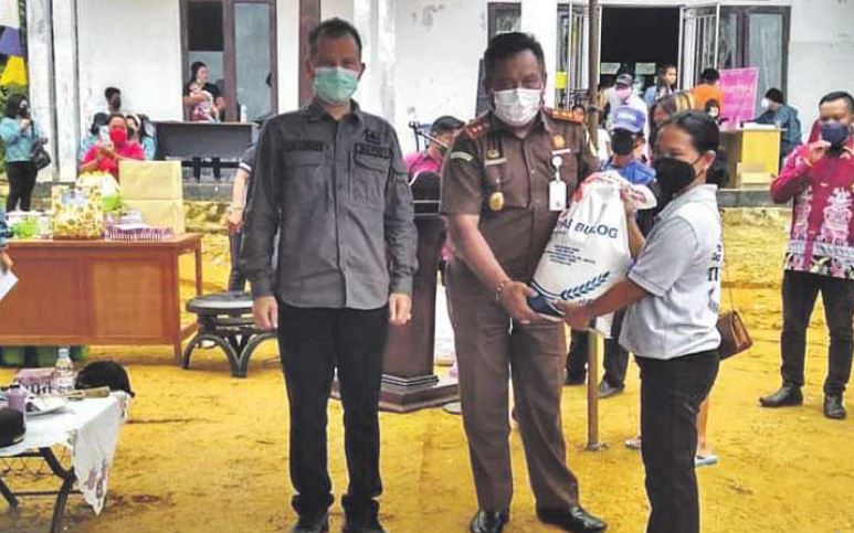 BAGI SEMBAKO: Bupati Gunung Mas Jaya Samaya Monong (kiri) bersama Kajari Gumas Anthony saat membagikan sembako kepada warga terdampak banjir, beberapa waktu lalu.