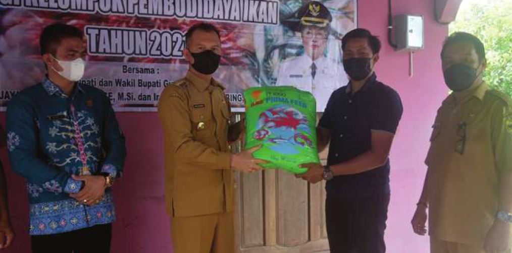 MENDAMPINGI : Wakil Ketua I Dewan Perwakilan Rakyat Daerah Gunung Mas Binartha (batik biru) saat mendampingi Bupati Gunung Mas Jaya Samaya Monong membagi benih ikan dan pakan, beberapa waktu lalu.