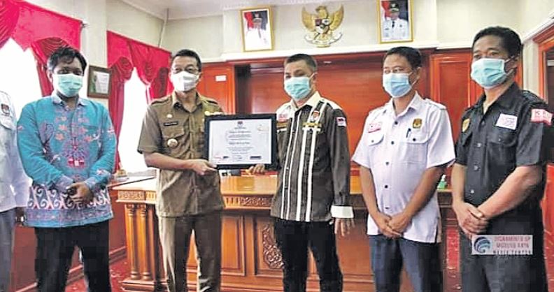 DAPAT PENGHARGAAN: Bupati Mura Perdie M Yoseph (dua dari kiri) mendapat penghargaan dari KPU Kalteng yang diserahkan Ketua KPU Mura, Sanjaya, Senin (12/7).