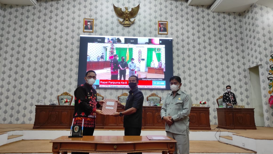 PENYERAHAN - Wakil Bupati Katingan Sunardi usai penandatanganan oleh Ketua DPRD Katingan Marwan Susanto pada rapat paripurna, Jumat (1/4/2022). FOTO : HUMAS SETDA KATINGAN