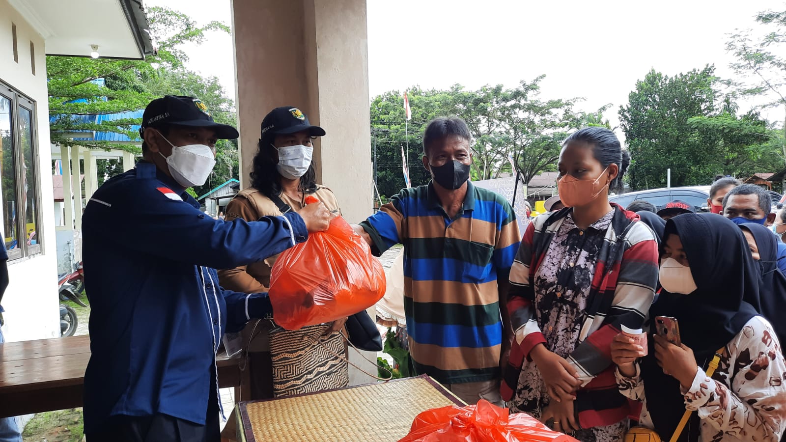 MENYERAHKAN : Kepala Bidang Perdagangan DPKUKMP Kota Palangka Raya Hadriansyah menyerahkan sembako pada operasi pasar sembako di Kelurahan Kereng Bangkirai, Selasa (19/4/2022).