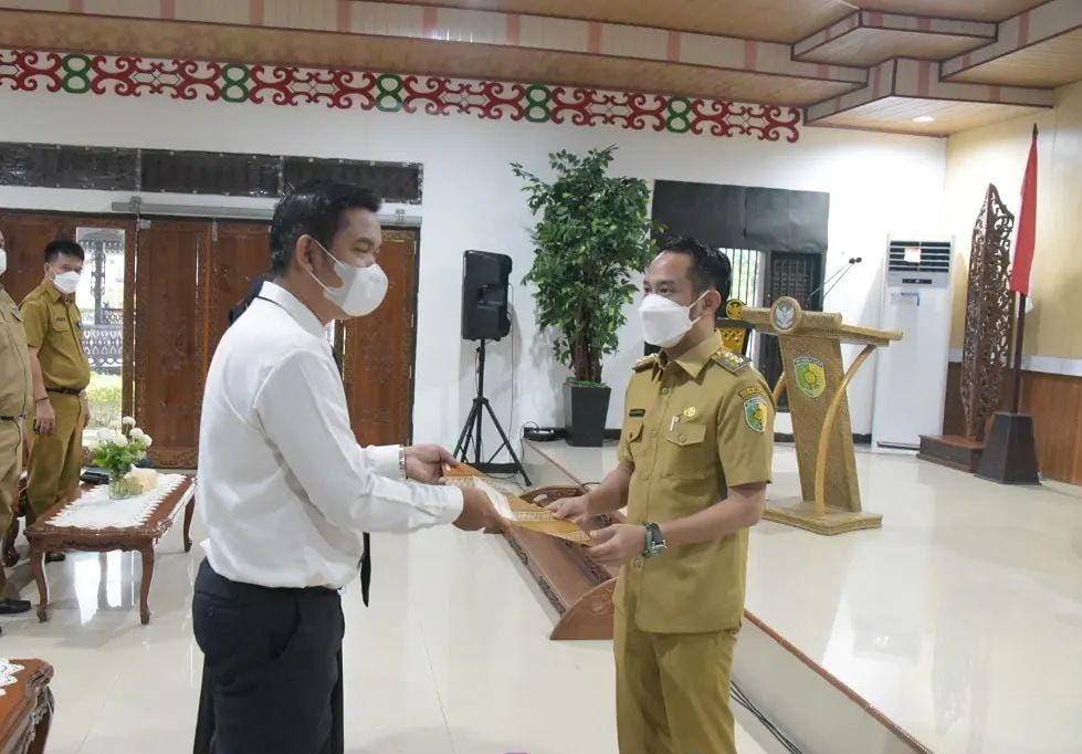 MENYERAHKAN : Wali Kota Palangka Raya Fairid Naparin (kanan) menyerahkan SK Pegawai Pemerintah dengan perjanjian kerja (PPPK) di Aula Rujab Wali Kota, Selasa (19/4/2022). PROKOM