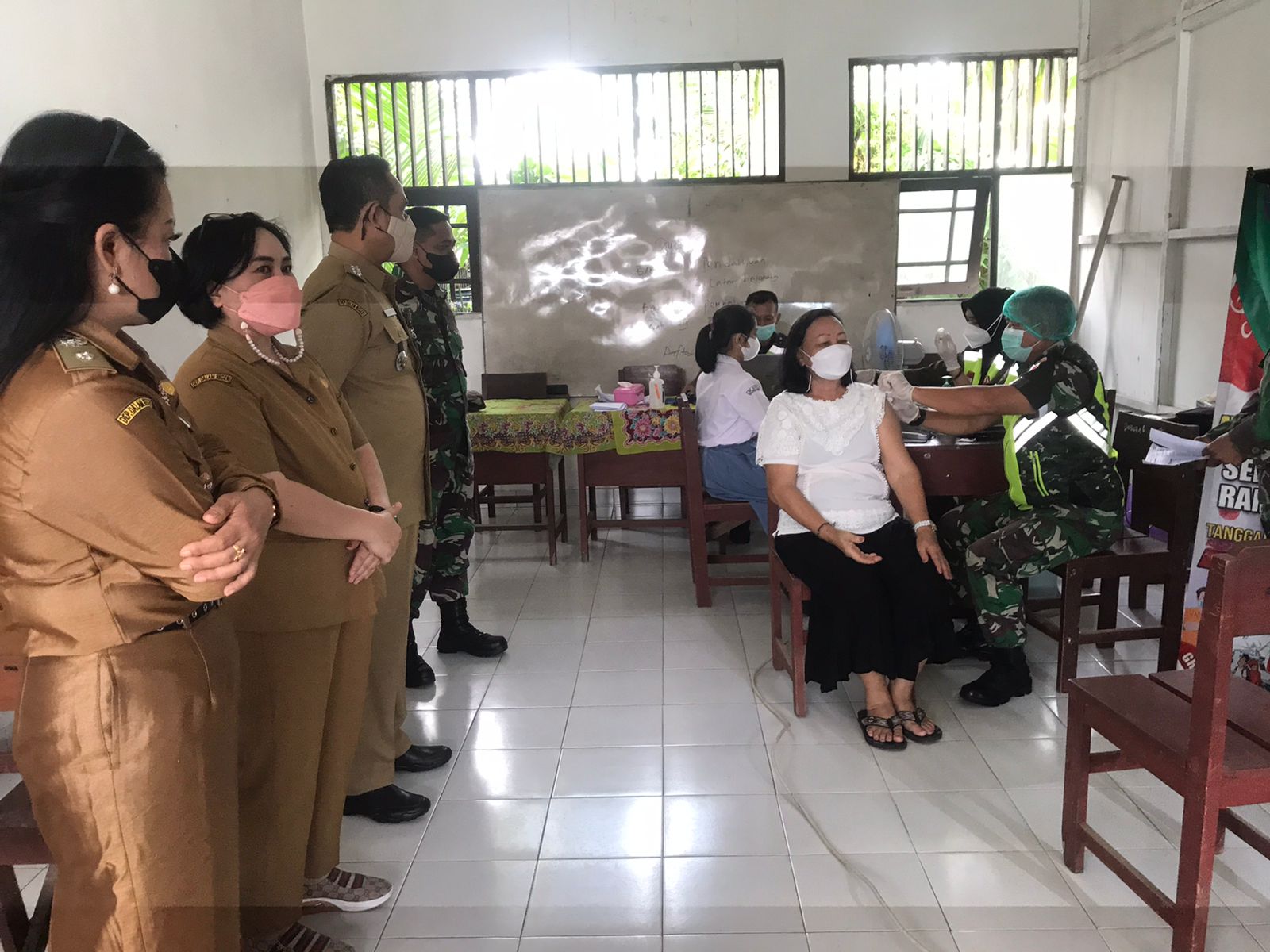 MENINJAU : Camat Pahandut Berlianto (tengah) memantau kegiatan vaksinasi di SMP dan SMA Purnama baru - baru ini. KECAMATAN PAHANDUT