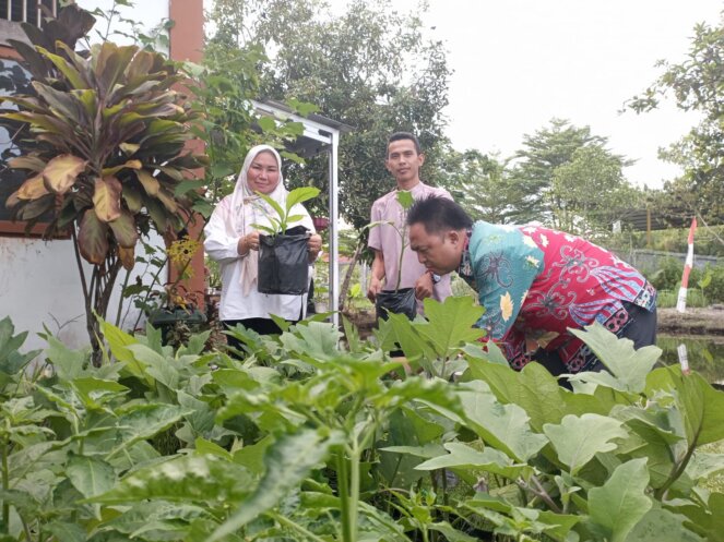 MENANAM : Lurah Panarung Evi Kahayanti beserta staf usai menanam sayur dan buah-buahan menggunakan media polybag, Rabu (25/5/2022). PATHUR KALTENG POS