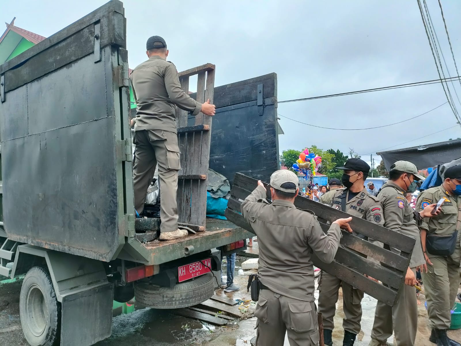 MENGANGKUT : Anggota Satpol PP Kota Palangka Raya saat mengangkut puing - puing bekas pedagang di bahu jalan, Kamis (30/6/2022). FOTO PATHUR