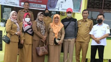 Kadiskan Palangka Raya Indriati Ritadewi (tiga dari kiri) berfoto bersama perangkat Kelurahan Bereng Bengkel, usai penyerahan bantuan perahu, Senin (29/8/2022).