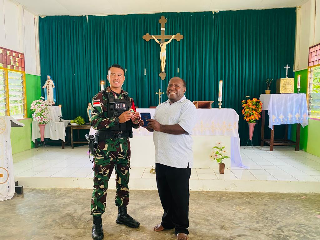 Satgas TNI Yonif R 631/Atg Bagikan Alkitab dan Kalung Rosario