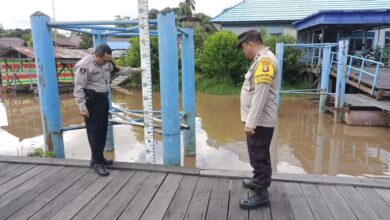 Petugas kepolisian ketika memantau debit air Sungai Rungan