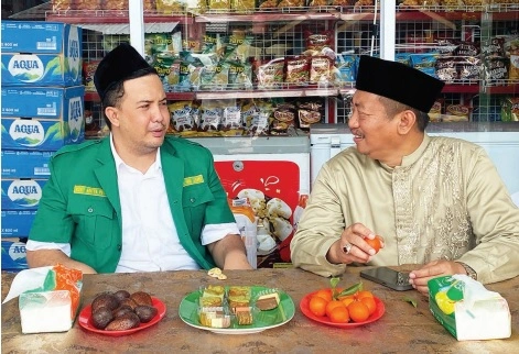 Bupati Lamandau, H Rizky Aditya Putra (samping kiri) bersama Bupati Sukamara H Masduki menyantap makan siang bersama di pinggir jalan usai mengikuti peringatan Haul Kyai Gede