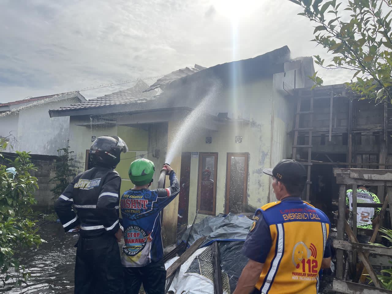 Petugas bersama relawan memadamkan api di rumah warga Jalan Markus Paul, Kelurahan Sabaru