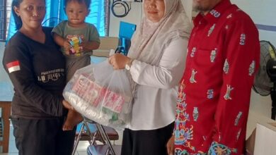 Lurah Panarung, Evi Kahayanti, SE., NL.P., didampingi Ketua LPMK Misran menyerahkan bantuan kepada anak beresiko stunting