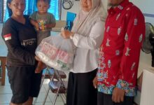 Lurah Panarung, Evi Kahayanti, SE., NL.P., didampingi Ketua LPMK Misran menyerahkan bantuan kepada anak beresiko stunting