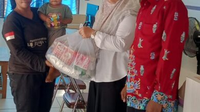 Lurah Panarung, Evi Kahayanti, SE., NL.P., didampingi Ketua LPMK Misran menyerahkan bantuan kepada anak beresiko stunting