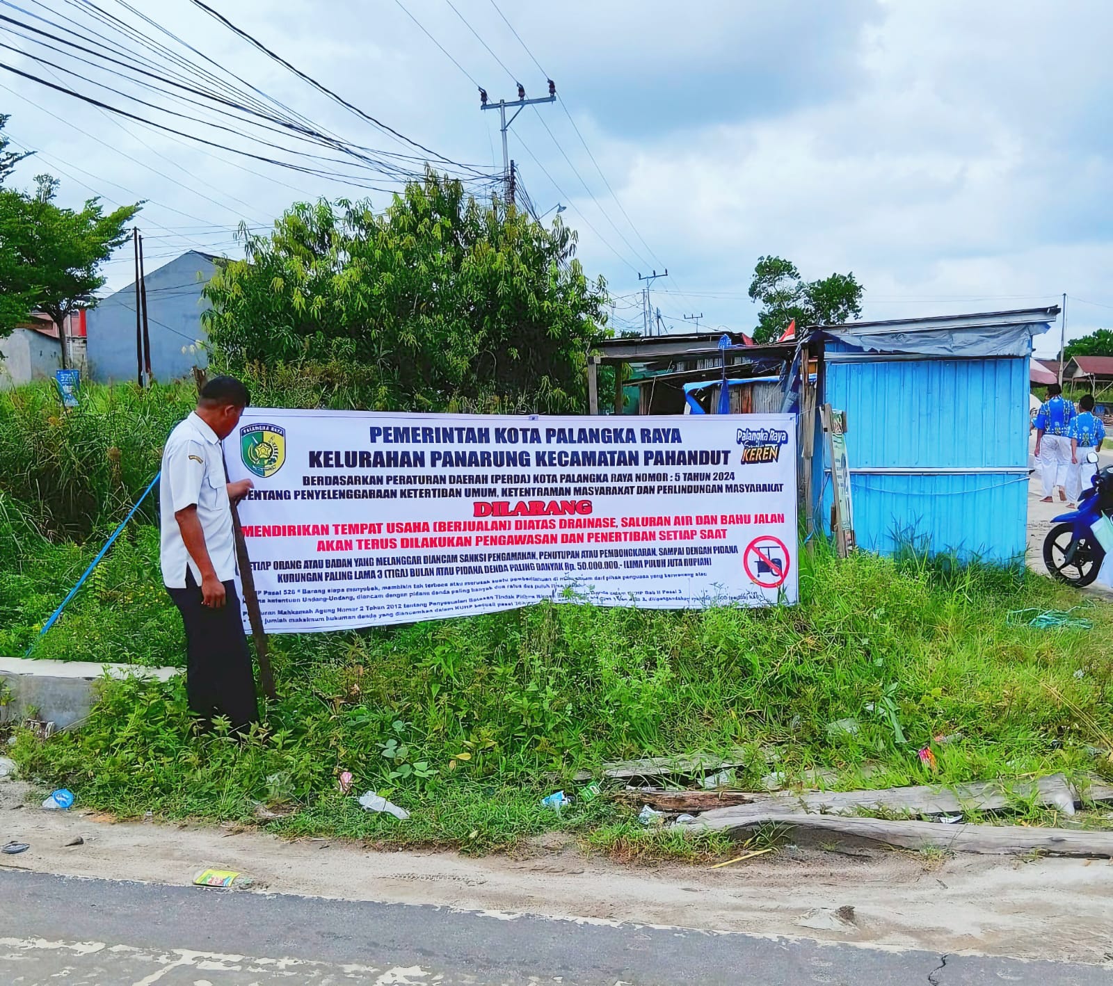 Kelurahan Panarung saat melakukan pemasangan spanduk sosialisasi larangan membangun di atas drainase Jalan Pinus