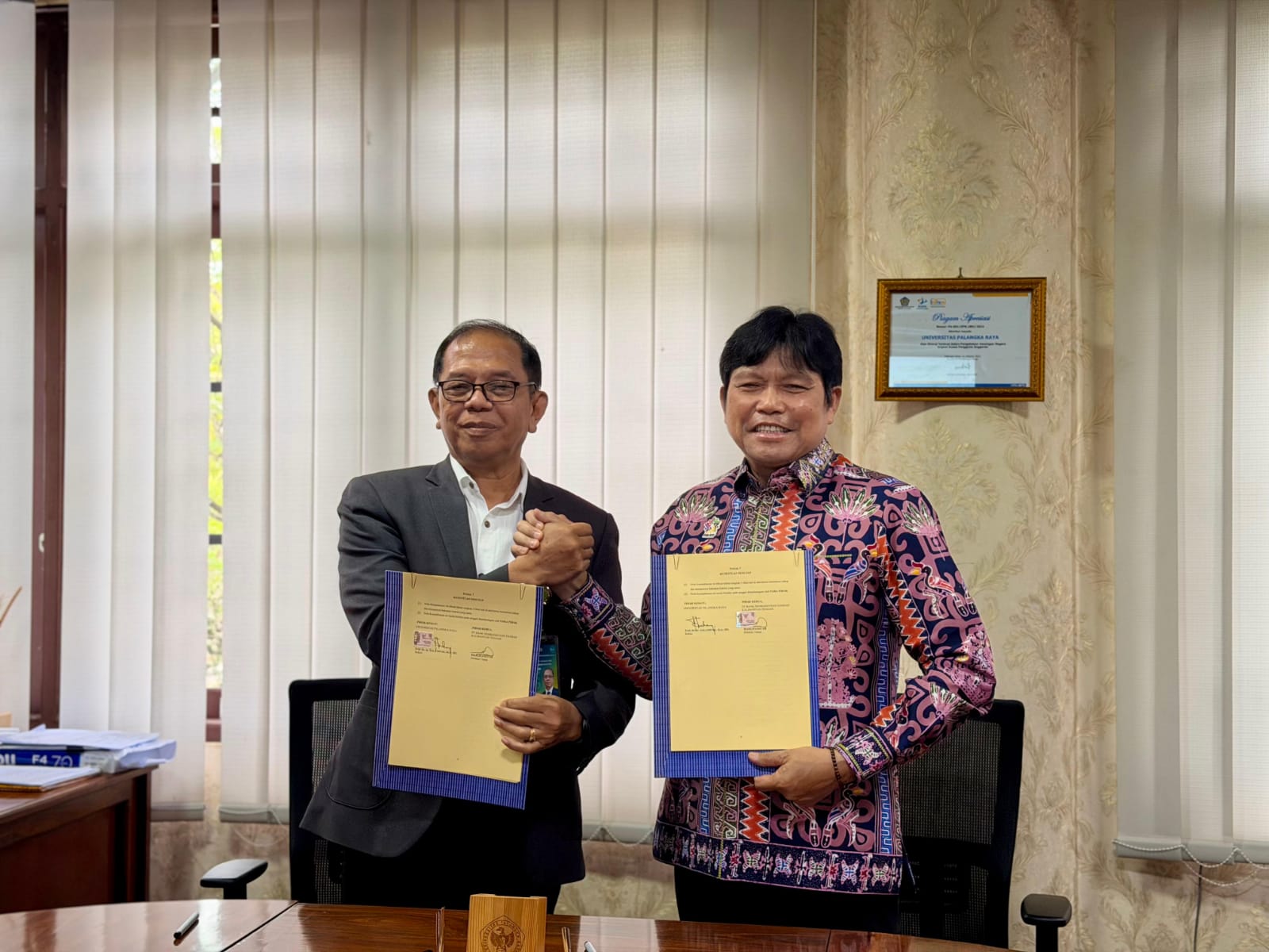 SINERGI: Direktur Utama Bank Kalteng, Maslipansyah foto bersama Rektor UPR, Salampak