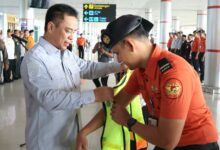 Kadishub Kalteng Yulindra Dedy saat menyematkan rompi kepada petugas pada Apel Pembukaan Posko Monitoring Angkutan Udara Lebaran 1447 H/2026 di Bandara Tjilik Riwut, Palangka Raya