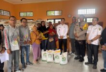 Bhabinkamtibmas Polsek Pahandut memastikan proses distribusi bantuan berjalan aman