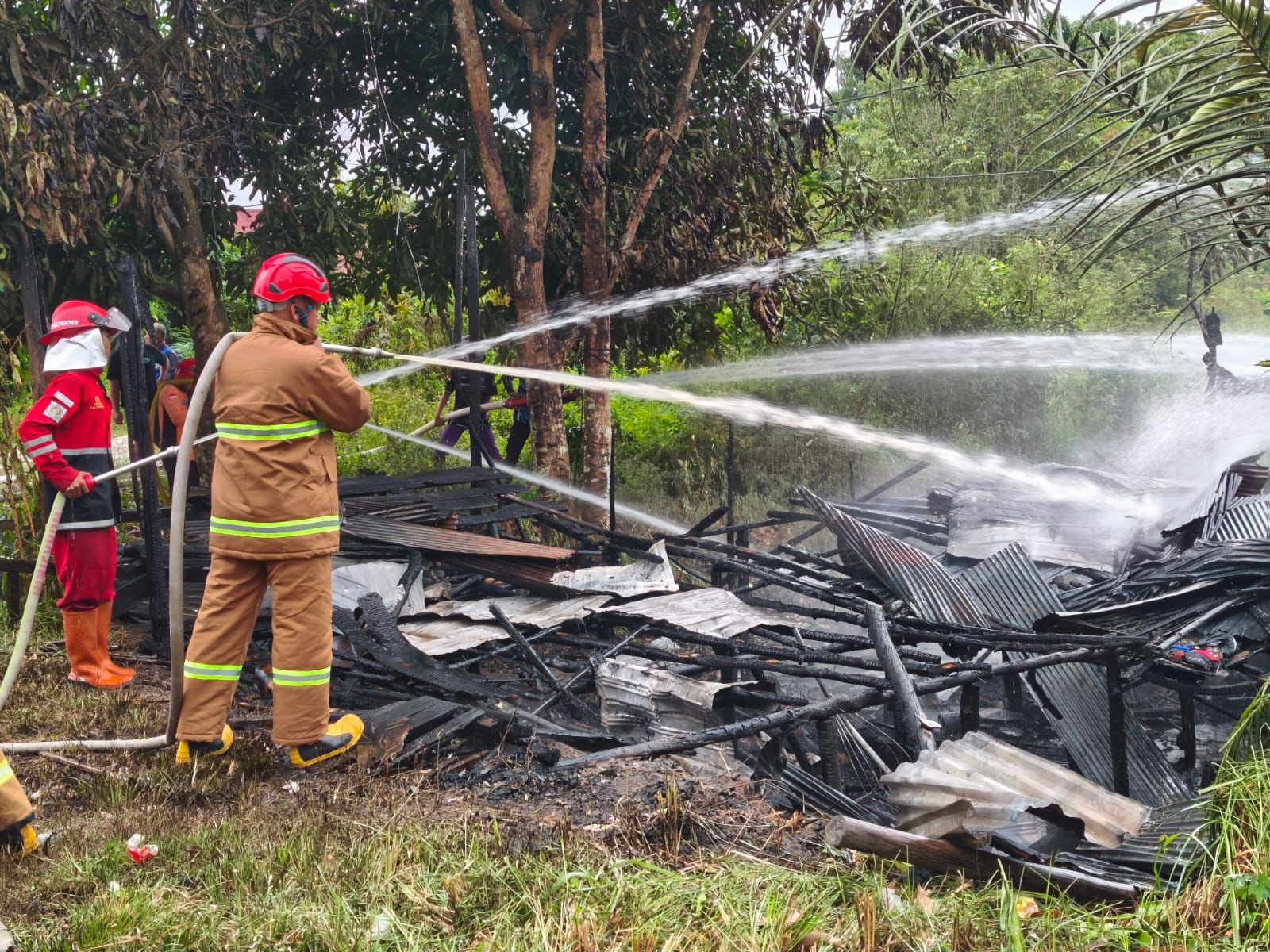 Petugas ketika melakukan pemadaman pada satu unit bangunan kayu yang terbakar, Jumat (3/4/2026) kemarin