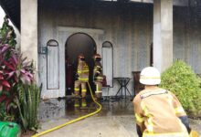 Petugas ketika melakukan pemadaman terhadap satu unit rumah yang terbakar