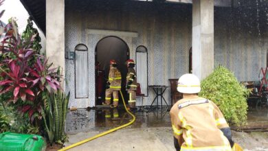 Petugas ketika melakukan pemadaman terhadap satu unit rumah yang terbakar