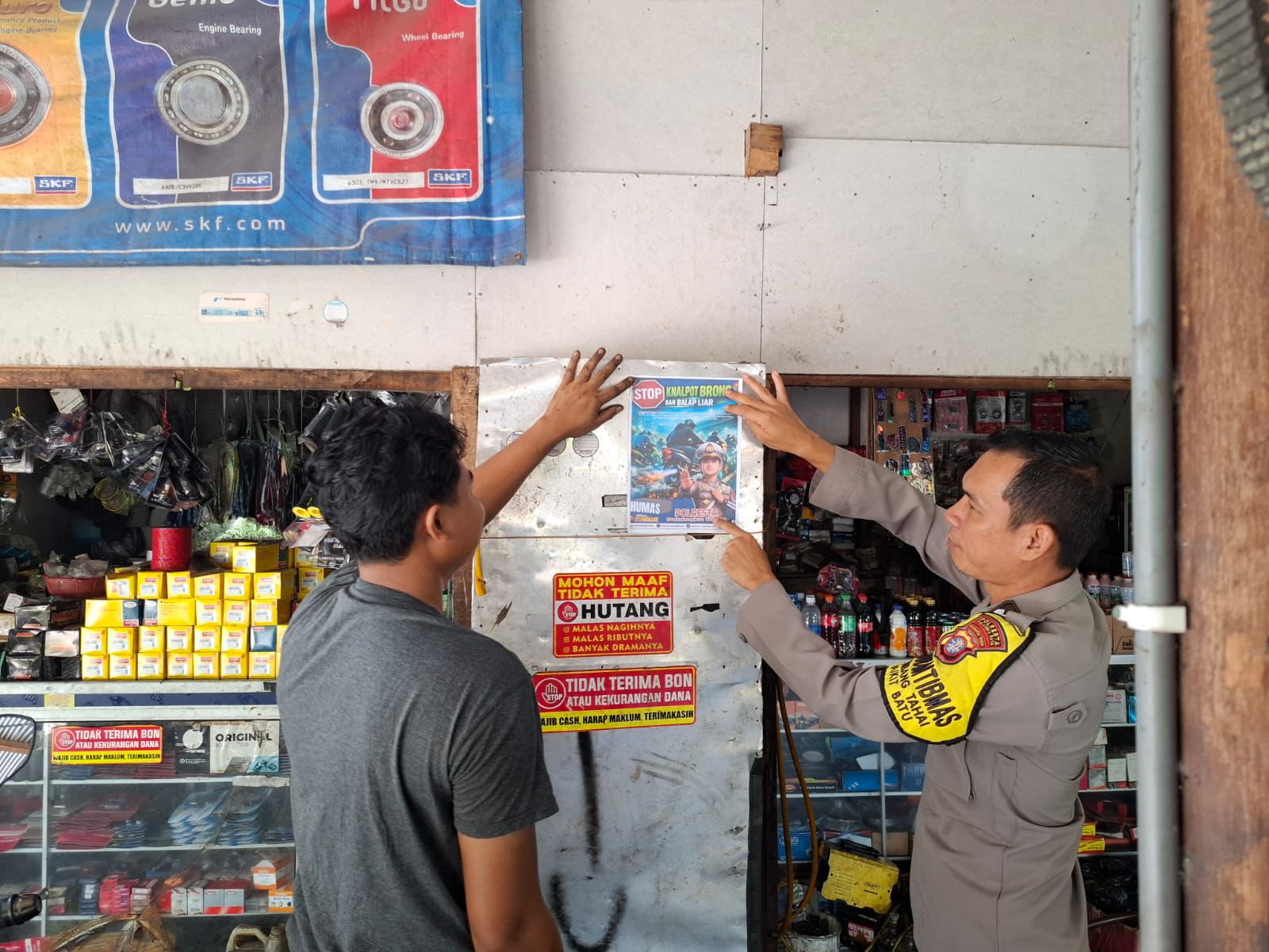 Personel kepolisian mendatangi salah satu bengkel mensosialisasikan larangan knalpot beong