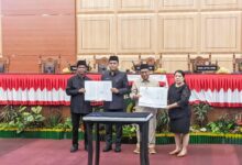 Ketua DPRD Kota Palangka Raya, Subandi bersama Wakil Wali Kota Palangka Raya, Achmad Zaini saat menunjukkan berita acara pengesahan Perda usai rapat paripurna