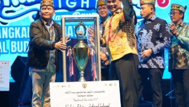 ‎JUARA UMUM: Bupati Barito Utara, H. Shalahuddin saat menerima piala penghargaan Juara Umum Festival Isen Mulang 2026 dari Gubernur Kalteng H. Agustiar Sabran