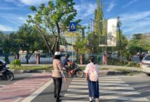 Personel Satlantas Polresta Palangka Raya mengatur arus lalu lintas di kawasan zona sekolah