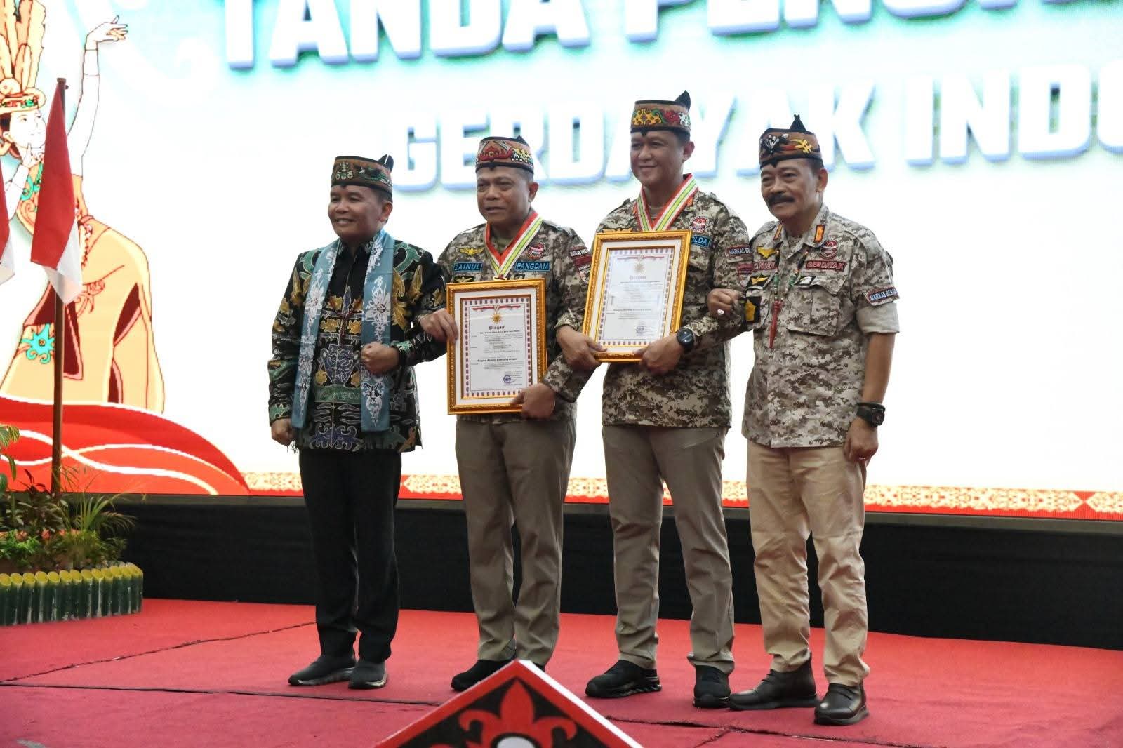 Pangdam XXII/TB, Mayjen TNI Zainul Arifin bersama Kapolda Kalteng, Irjen Pol Iwan Kurniawan saat menerima Tanda Penghargaan, Medali Penghormatan, dan Piagam GERDAYAK Indonesia “Tingang Menteng Bapenyang Simpei”, pada peringatan HUT ke-16 GERDAYAK Indonesia