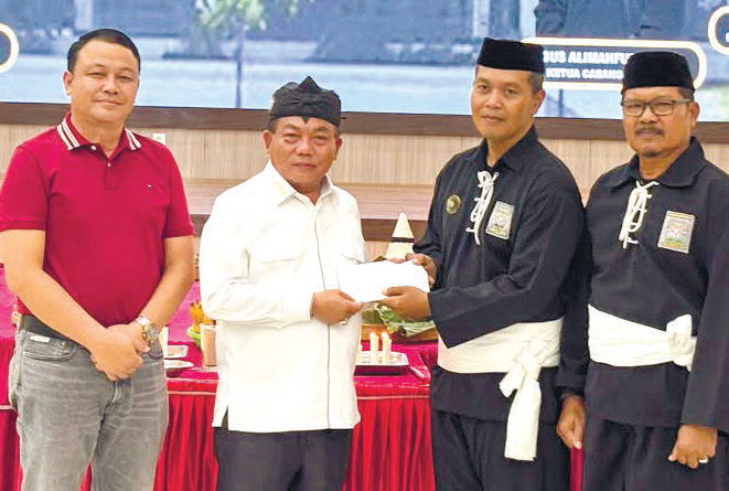 Bupati Kapuas HM Wiyatno menyerahkan tali asih kepada Ketua Cabang PSHT Kapuas Agus Alimahfudin