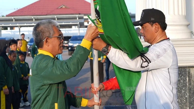 Bupati Barito Utara H Shalahuddin ST MT secara simbolis menyerahkan Pataka kepada Kepala Dinas Pendidikan Kabupaten Barito Utara M Iman Topik pada pelepasan Atler Pelajar di Ajang Olimpiade Olahraga Siswa Nasional (O2SN) di Halaman Kantor Bupati Barito Utara, Minggu (12/7).