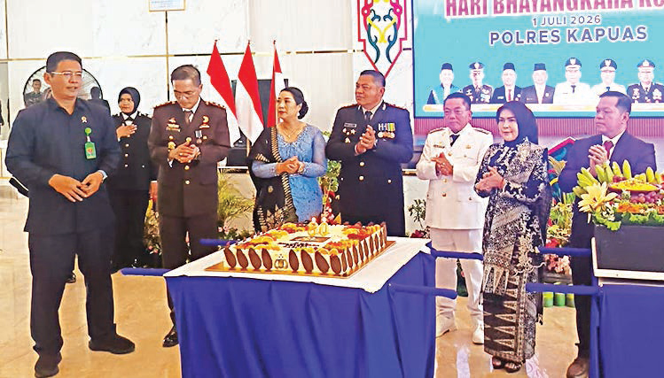 Kapolres Kapuas AKBP Gede Eka Yudharma memberikan potongan tumpeng kepada Bupati Kapuas HM Wiyatno saat syukuran hari Bhayangkara ke- 80