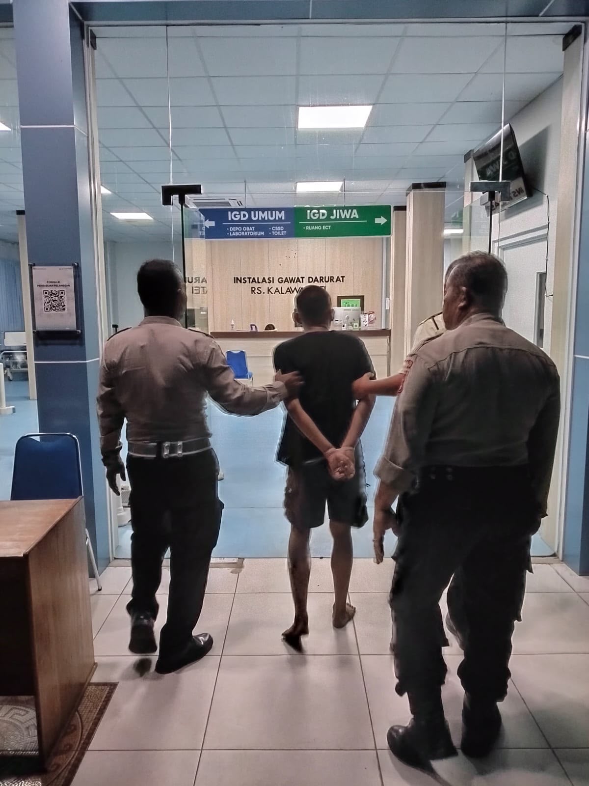 Petugas kepolisian saat mengamankan seorang pria mengamuk membawa sajam