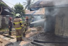 Petugas melakukan pemadaman di barak dua pintu di Panarung yang terbaka