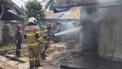 Petugas melakukan pemadaman di barak dua pintu di Panarung yang terbaka